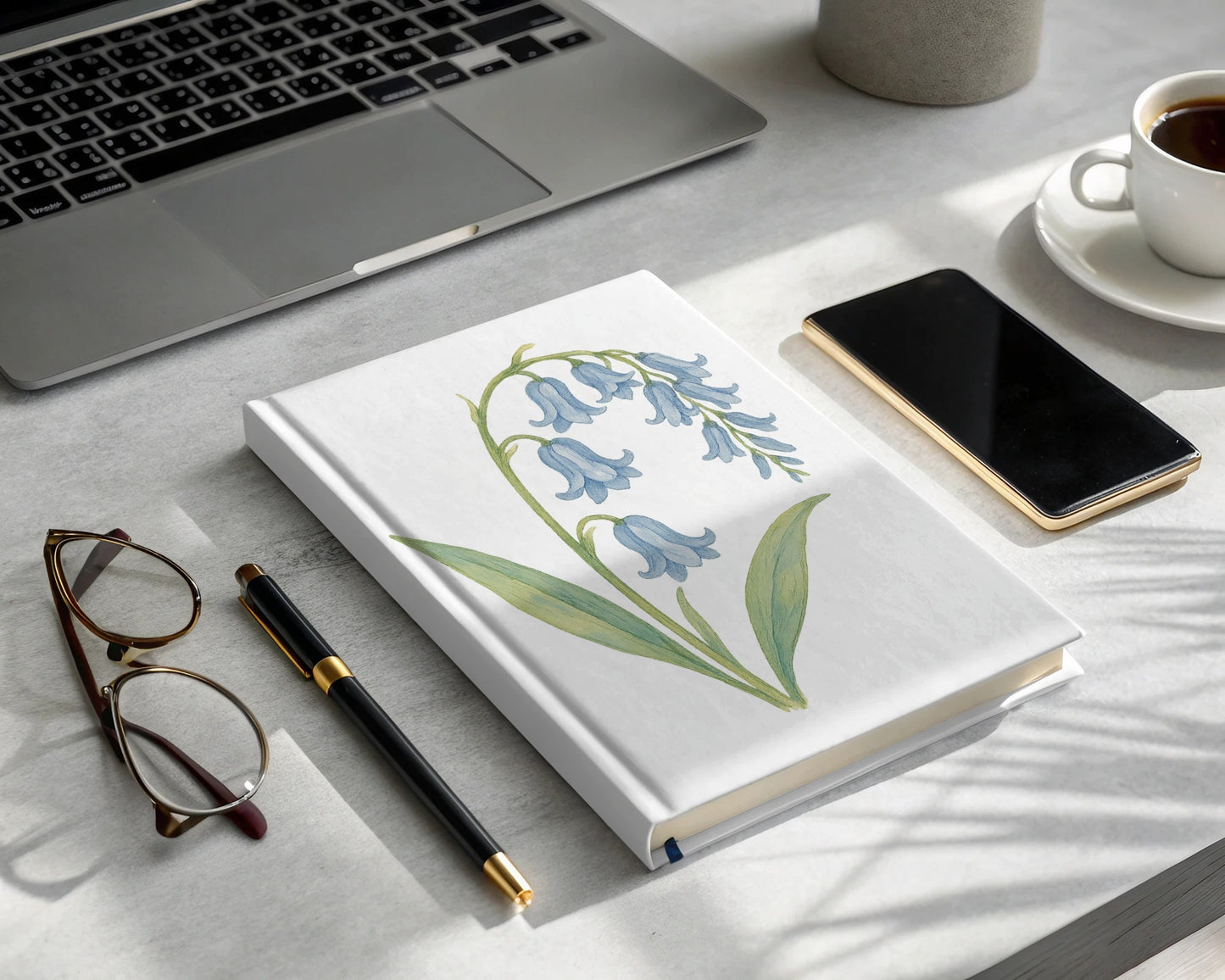 Laptop work desk with floral bluebell notebook product
